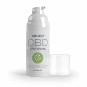 Eine Flasche Zemadol, pflegende CBD-Creme neben einem Glas.