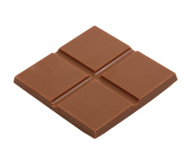 Ein Stück CBD-Milchschokolade auf weißem Hintergrund.